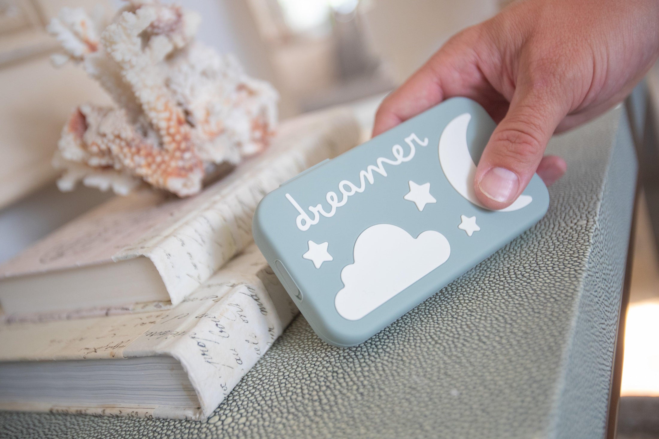 Dreamer baby sound machine held in hand to show scale (Sage-Dreamer)