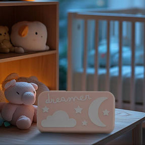 Dreamer baby sound machine in a softly lit nursury (Peach-Dreamer)