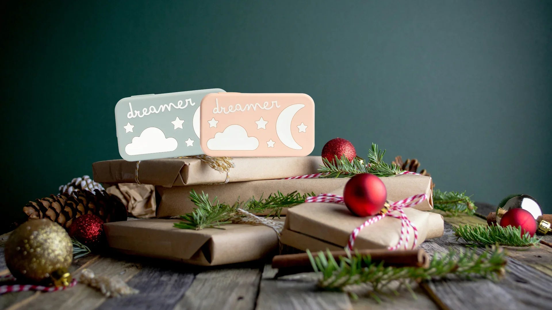 Decorative wooden signs with cloud designs on a table with Christmas decorations.